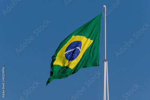 Flag of Brazil fluttering in the wind. In the center of the flag with the words "order and progress" in Portuguese