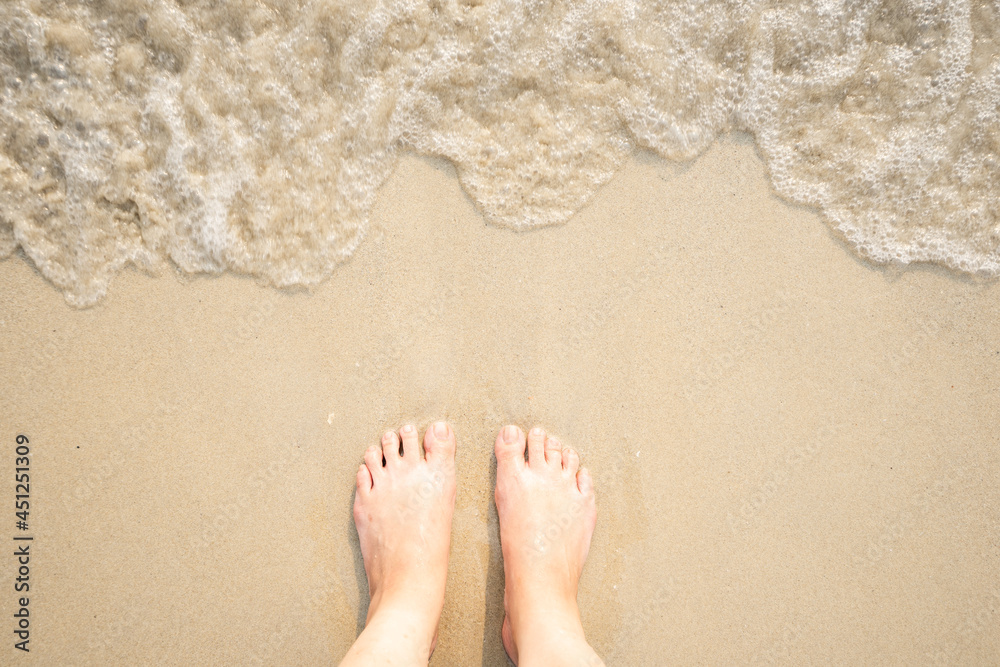 Waves and naked feet on a sand beach, Vacation on ocean beach
