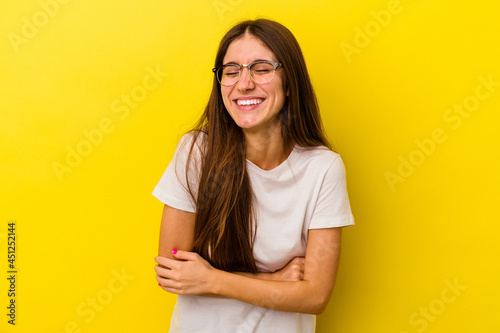 Young caucasian woman isolated on yellow background laughing and having fun.