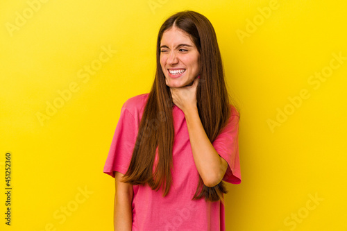 Young caucasian woman isolated on yellow background touching back of head, thinking and making a choice.