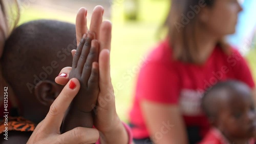 Caucasian white volunteers with African children. Hand to hand. Beautiful shot. Volunteering orphanage program of an NGO in Africa. photo