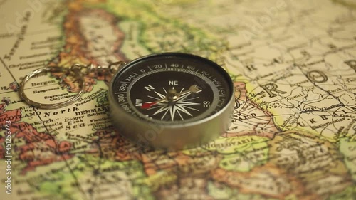 Spinning compass on world map background. Vintage travel and navigation footage 