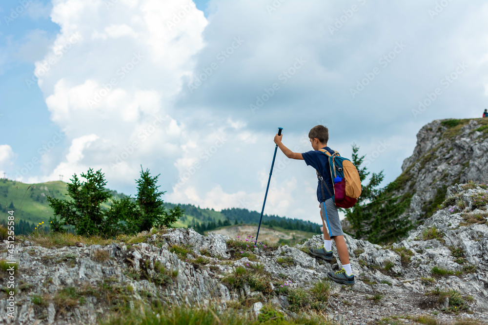 Brave boy on top of mountain. Hiker climbed on peak of rock above foggy valley. Boy on a stone observing the landscape. Wallpaper with space for your montage - aim, top, business, thinking concept 