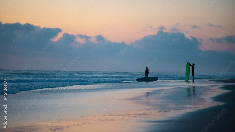 Surfer am Strand nach einer Session. Wellenreiten. Sonnenuntergang