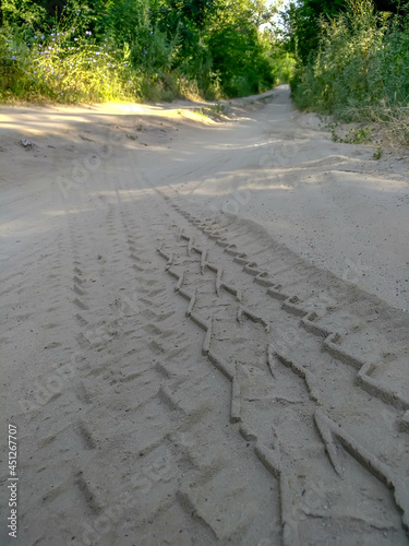 Trail from a car on a sandy forest road. Close-up. Blurred background.