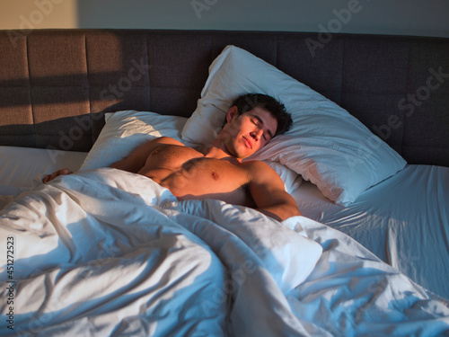Bild auf Leinwand Handsome shirtless young man in bed sleeping