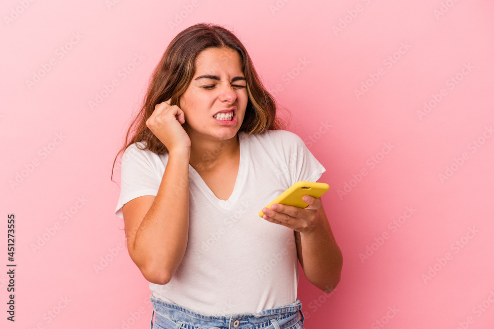 Young caucasian woman using mobile phone isolated on pink background covering ears with hands. Young caucasian woman using mobile phone isolated on pink background covering ears with hands.