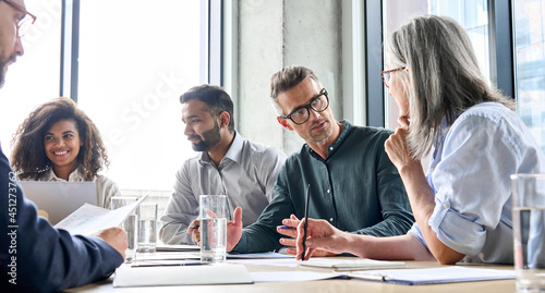 Diverse business people partners group negotiating at boardroom meeting.Multiethnic executive team discussing financial partnership agreement project strategy brainstorming sitting at table in office.