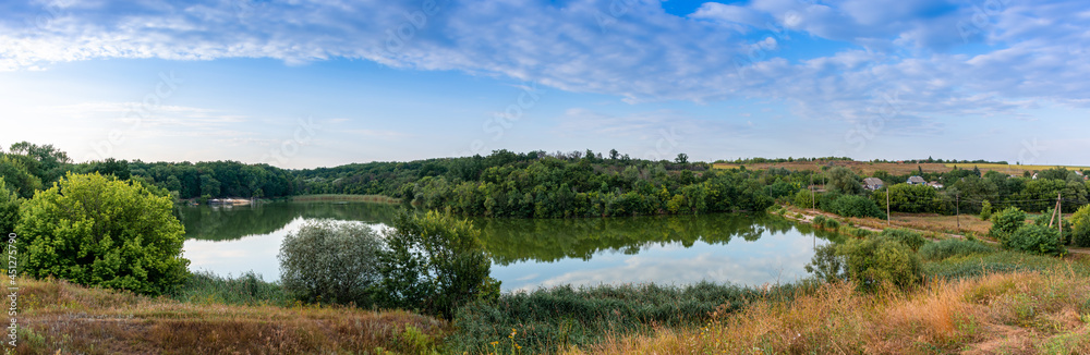 Picturesque lake among green reeds, rural landscape, panoramic shot