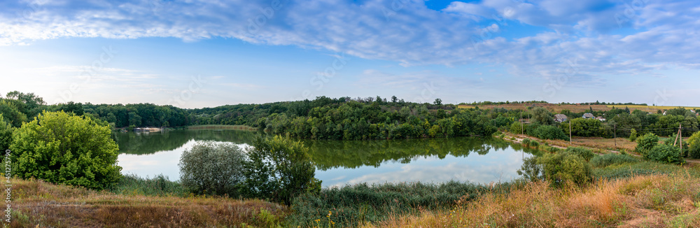 Picturesque lake among green reeds, rural landscape, panoramic shot Picturesque lake among green reeds, rural landscape, panoramic shot