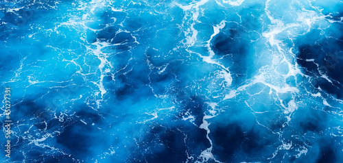 Waves and blue water as a background. View at the ocean surface. Natural summer seascape. Water background. Abstract blue ocean background.