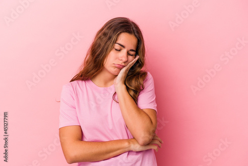 Young caucasian woman isolated on pink background  who is bored, fatigued and need a relax day.