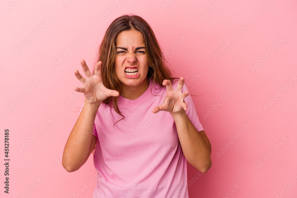 Young caucasian woman isolated on pink background showing claws imitating a cat, aggressive gesture. Young caucasian woman isolated on pink background showing claws imitating a cat, aggressive gesture.