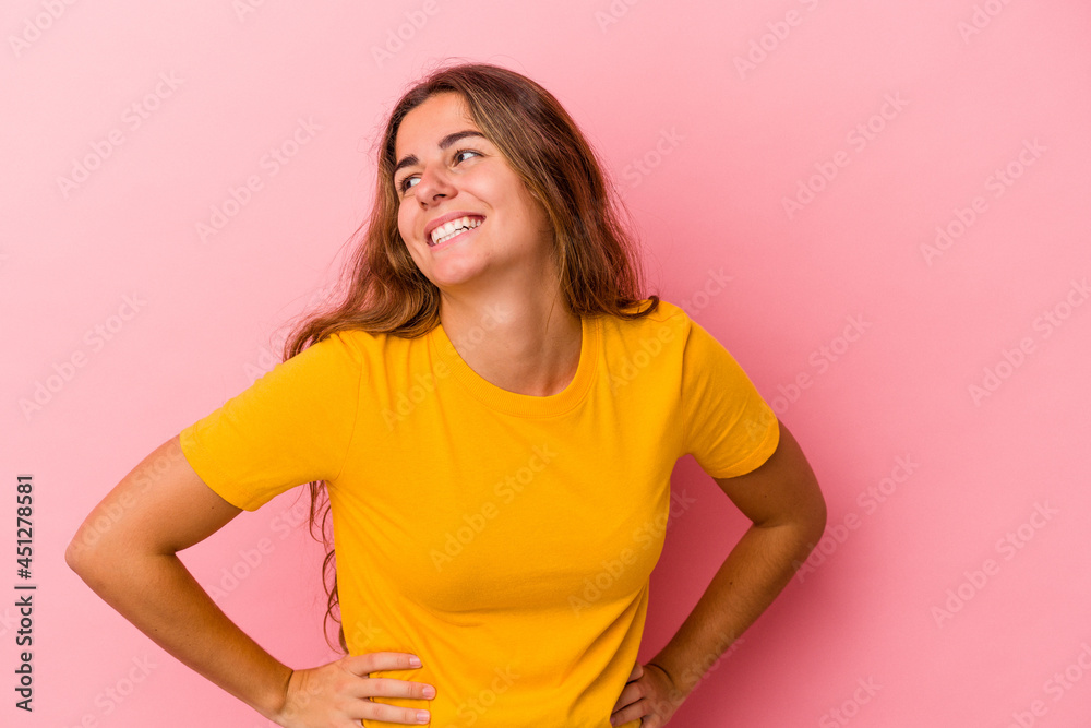 Young caucasian woman isolated on pink background laughs happily and has fun keeping hands on stomach. Young caucasian woman isolated on pink background laughs happily and has fun keeping hands on stomach.
