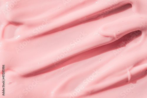 Pink color cosmetic cream lotion moisturizer smear smudge sample. Beauty cream texture background. Skin care product strokes closeup. Creamy textured backdrop