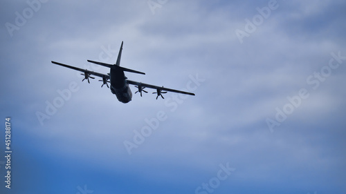 Hercules C-130 Transport aircraft banking to starboard in a cloudy sky