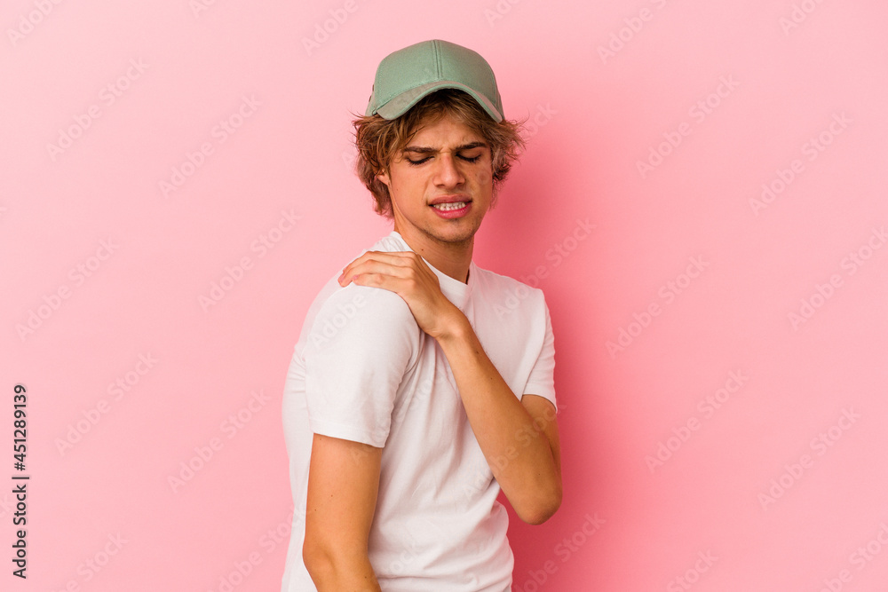 Young caucasian man with make up isolated on pink background having a shoulder pain.