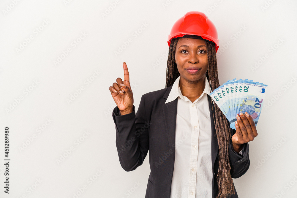 Young african american architect woman holding bills isolated on white background showing number one with finger. Young african american architect woman holding bills isolated on white background showing number one with finger.