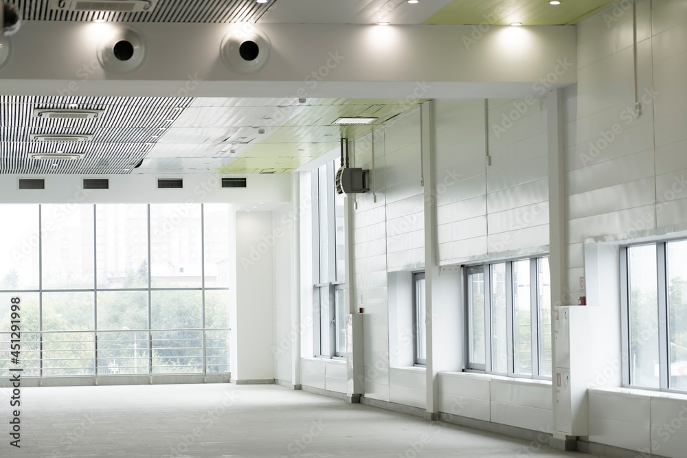 Fototapeta premium Interior empty corridor, lobby hall of modern office building with glass wall and sunlight shine through