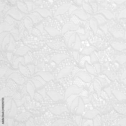 White lace fabric with a floral ornament. A feminine background best for invitations or wedding designs.