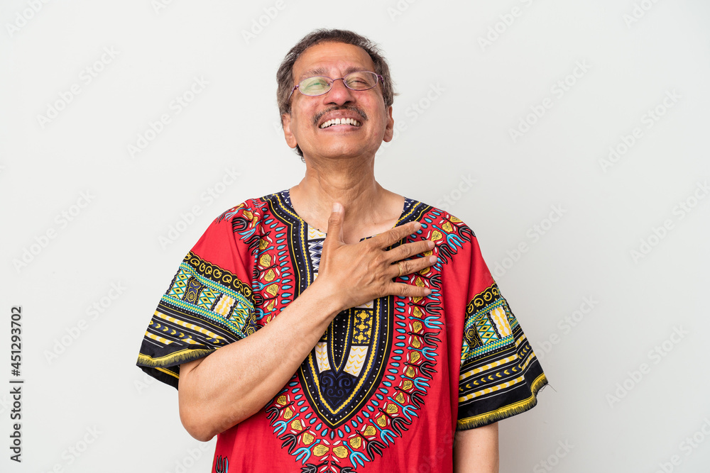 Obraz premium Senior indian man wearing a Indian costume isolated on white background laughs out loudly keeping hand on chest.