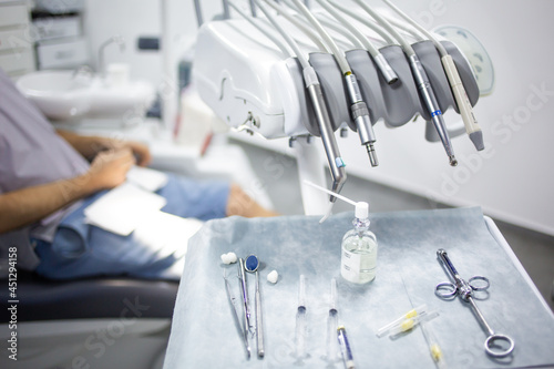 Medical tray table with dental tools, medicines and equipment, patient in a dental chair on a background