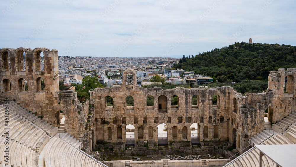 Remains of The Odeon of Herodes Atticus in Athens. Cityscape of Athens at cloudy day. Acropolis hill.