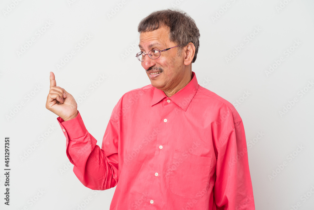 Middle aged indian man isolated on white background pointing with finger at you as if inviting come closer.