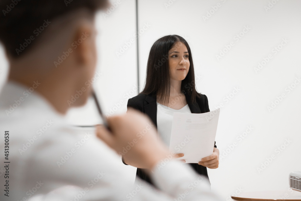 Exposicion de una mujer joven en una conferencia de trabajo junto a un chico Exposicion de una mujer joven en una conferencia de trabajo junto a un chico