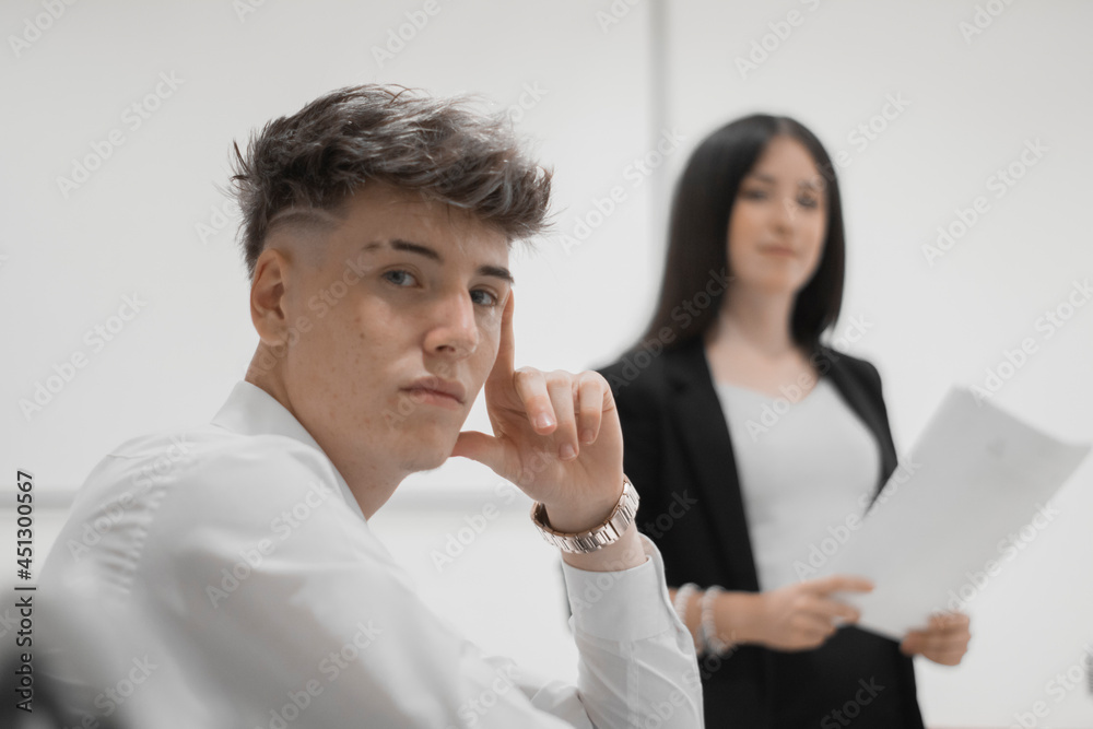 Chica joven en una conferencia de trabajo explicando informes de trabajo junto a un muchacho Chica joven en una conferencia de trabajo explicando informes de trabajo junto a un muchacho