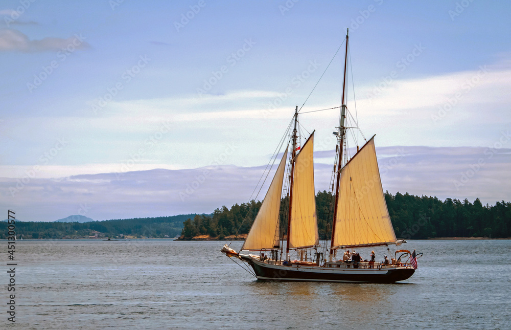 Gaffer schooner sailboat with sails up with San Juan Islands in background, Washington State Gaffer schooner sailboat with sails up with San Juan Islands in background, Washington State