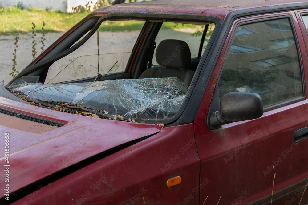 old dirty and rusty passenger car with a broken red windshield stands on the street old dirty and rusty passenger car with a broken red windshield stands on the street