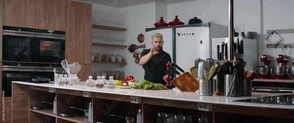 Cooking TV show celebrity host cooking a dish, talking into camera Cooking TV show celebrity host cooking a dish, talking into camera