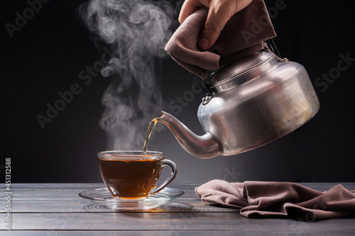 organic hot tea placed on a wooden table on a black background