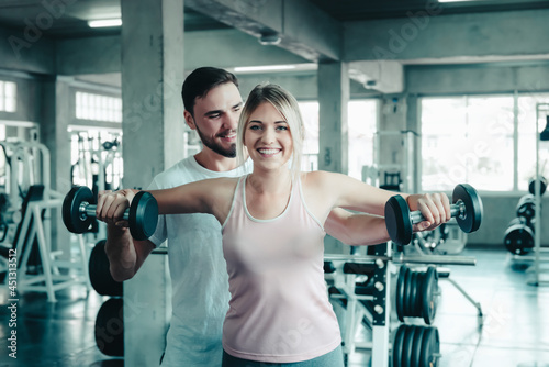 Couple Love Exercising Workout in Fitness Training Room  Young Couple Caucasian Working Out and Exercise Training Together With Dumbbell Equipment in Fitness Club. Fitness Sport Trainer Lifestyles