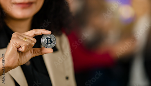 Close up shot of silver bitcoin cryptocurrency virtual token coin in professional successful female businesswoman trader investor hand with copy space in blurred background