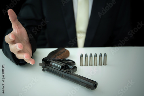 Unrecognizable Asian businessman draw the gun from gun holder inside his suit.