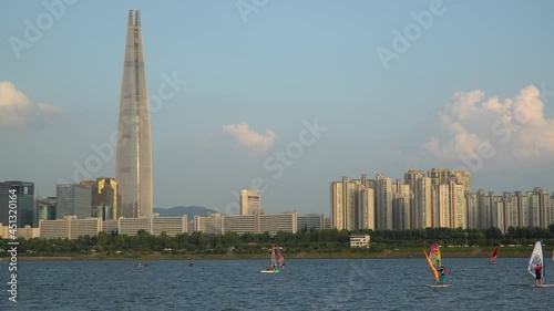 Windsurfers in the Han River, Lotter world Tower on the background at sunset, Seoul, South Korea photo