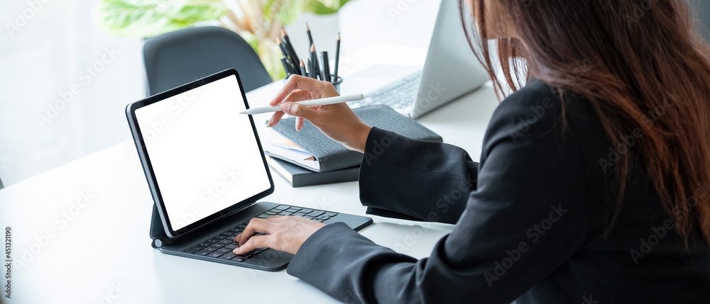 Cropped shot of a business woman sitting at modern office room and using blank screen digital tablet computer with pen stylus - obrazy, fototapety, plakaty 