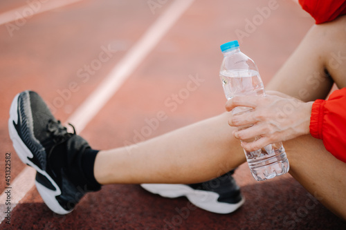 Feet of a female runner who is stepping on the running field with strength. Exercising in the summer with running methods to keep your body healthy.