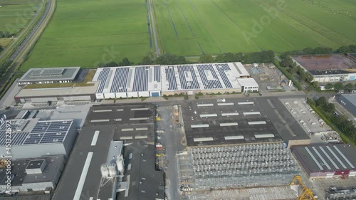 Flying towards distant industrial building with solar panels on roof photo
