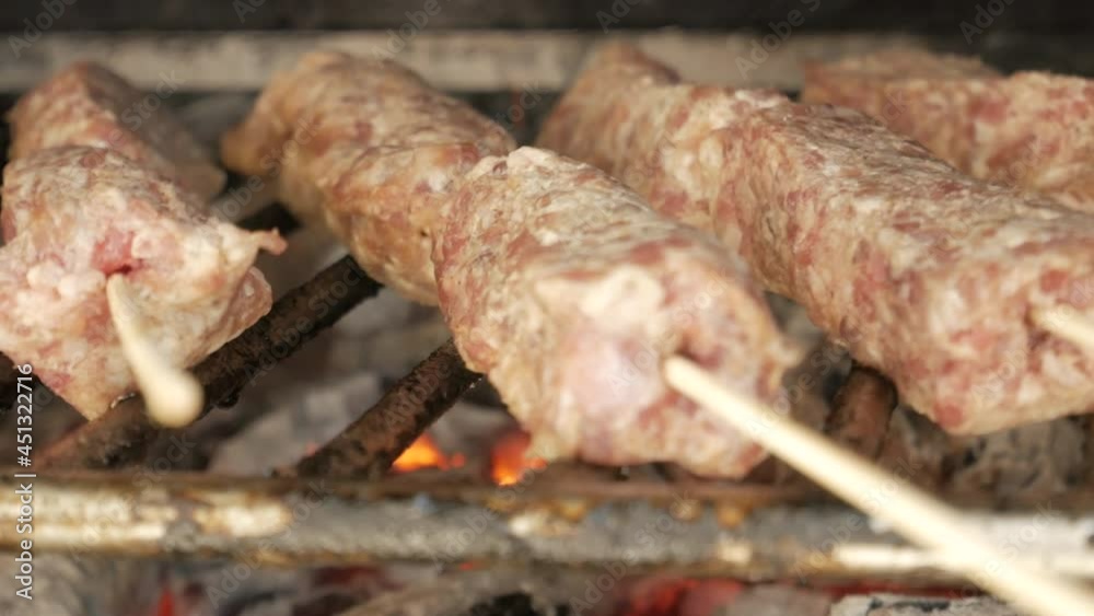 Close up View Of Mititei (Mici) On Griller Grilled Over Charcoal For Main Course. - handheld Close up View Of Mititei (Mici) On Griller Grilled Over Charcoal For Main Course. - handheld