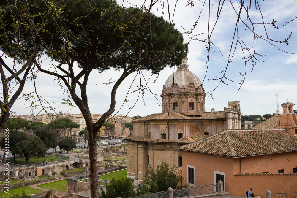 View of Rome from the Capitoline hill.Behind the trees, the Church of Santa Maria Aracoeli against the background of the city and the sky