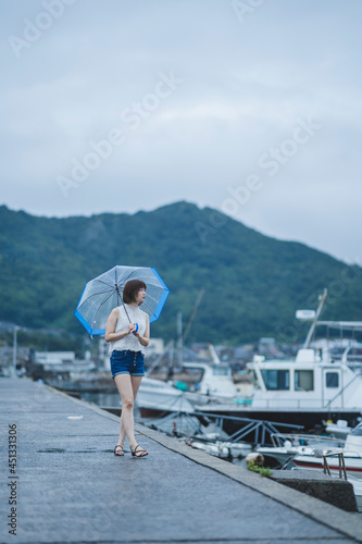 Fototapeta Naklejka Na Ścianę i Meble -  雨の日の海にいる女性