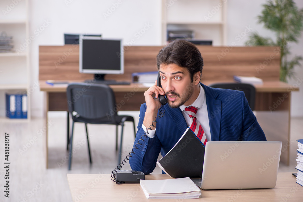 Young male employee working in the office Young male employee working in the office