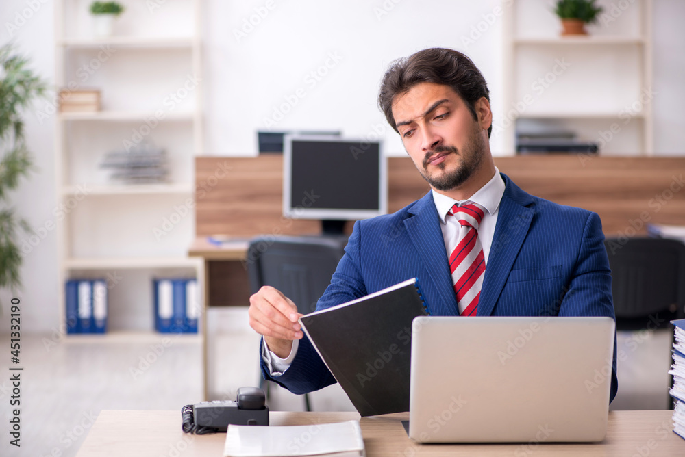 Young male employee working in the office Young male employee working in the office