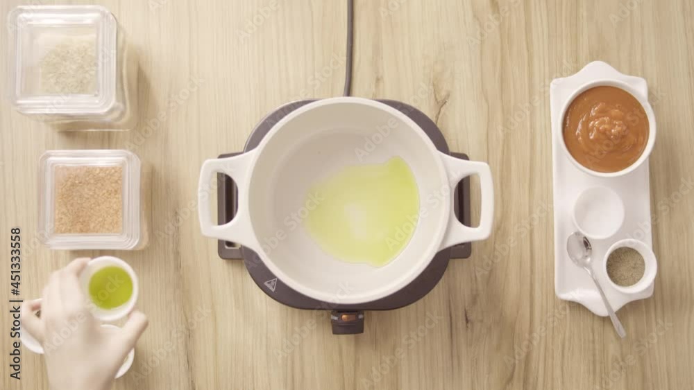 Pouring Oil in a Pot, Mixing it with Garlic and stir, Top View Static. Pouring Oil in a Pot, Mixing it with Garlic and stir, Top View Static.