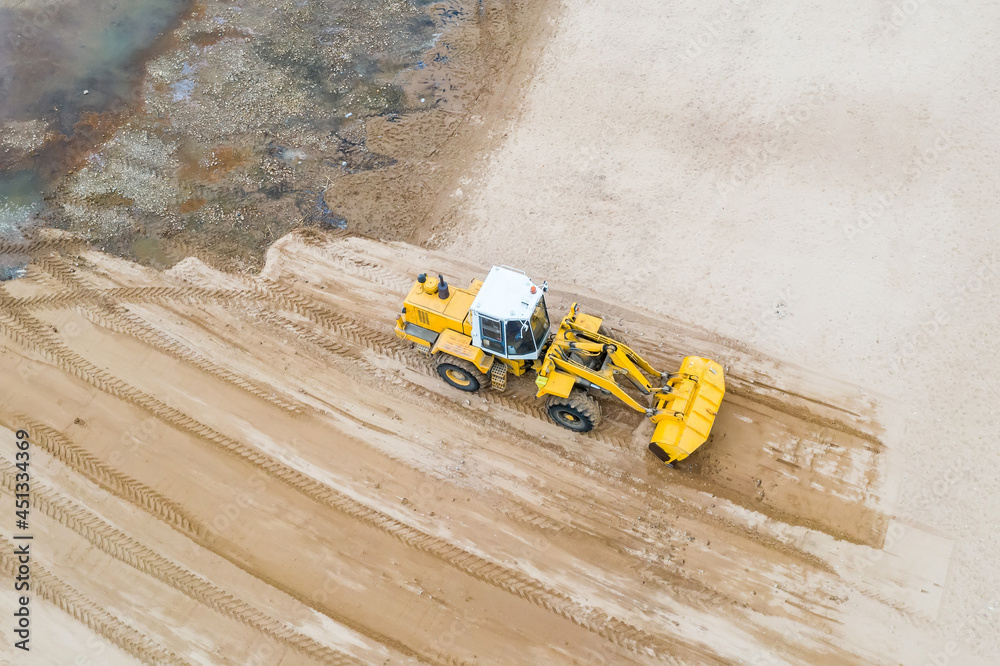 Aerial view of the working earth mover grader flattens the surface. Aerial view of the working earth mover grader flattens the surface.