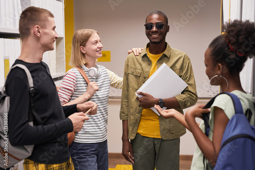 Fotografie, Tablou Waist up portrait of diverse group of students chatting with smiling blind man