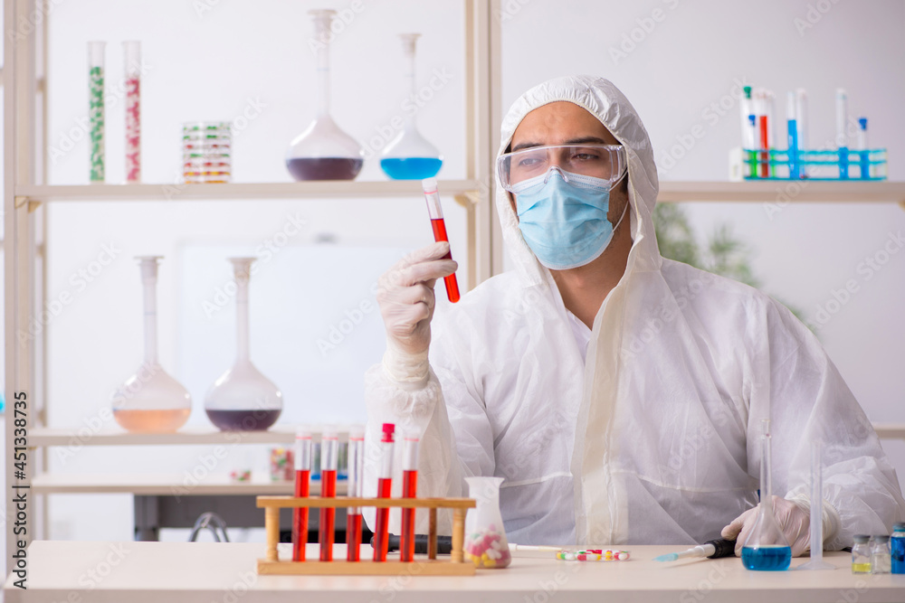 Young male chemist in drugs syntesis concept Young male chemist in drugs syntesis concept
